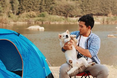 Man with dog on lakeshore at camping