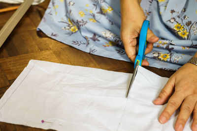 High angle view of woman cutting paper