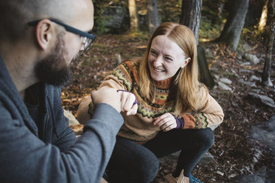 Smiling couple fist bumping in forest