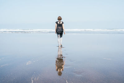 Full length of man standing at beach against sky