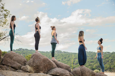 Group of people standing on land against sky