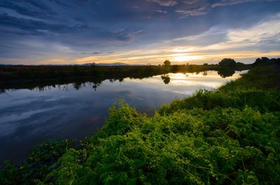 Scenic view of lake against sky at sunset