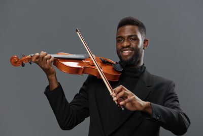 Portrait of man playing violin against white background