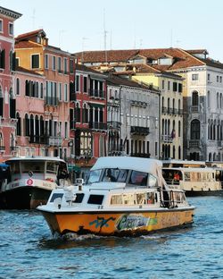 Boats in sea against buildings in city