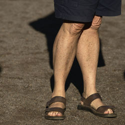 Low section of woman standing on footpath