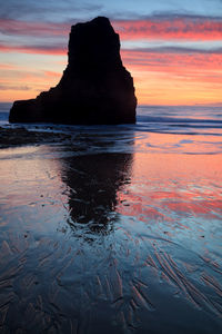 Scenic view of rocks in sea during sunset