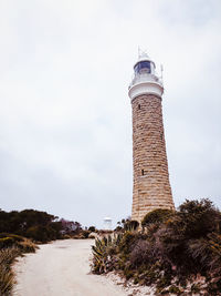 Low angle view of lighthouse on building against sky