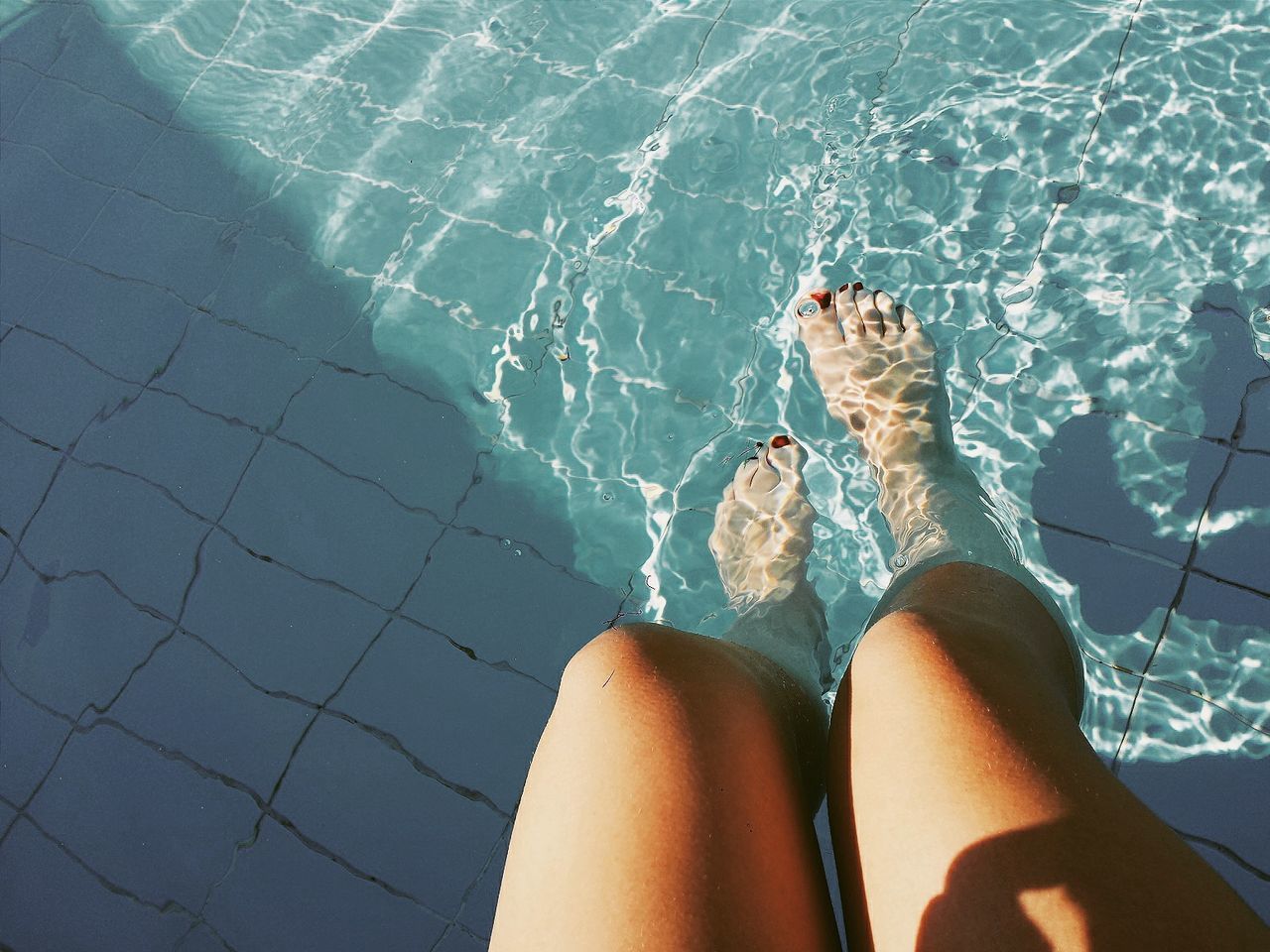 Woman's legs in swimming pool