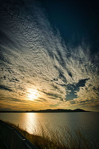 Scenic view of sea against dramatic sky during sunset