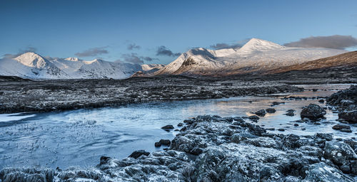 Sunrise over a frozen lochan na h-achlaise on rannoch moor in the scottish highlands