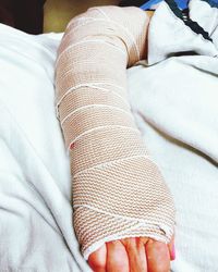 Close-up of hand on bed