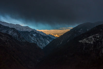 Scenic view of snowcapped mountains against sky at sunset