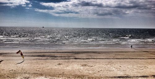 Man surfing on beach against sky