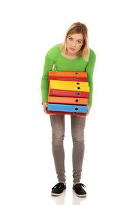 Portrait of a young woman standing against white background