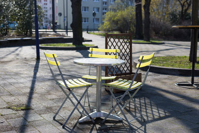 Yellow bistro chairs or garden chairs at a stainless steel bistro table or outdoor garden table