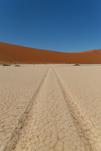 Scenic view of desert against clear blue sky