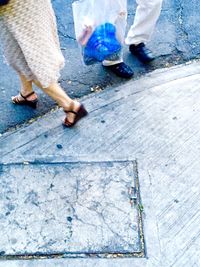 Low section of man and woman standing on tiled floor