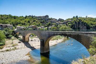 Arch bridge over river against sky