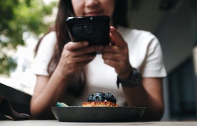 Midsection of man using mobile phone