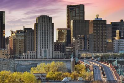 Modern cityscape against sky during sunset