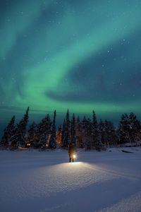 Snow covered landscape against sky at night