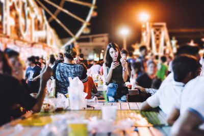 People at amusement park at night