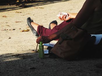 Low section of people sitting on sand