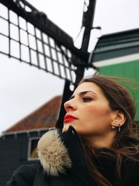 Thoughtful woman against traditional windmill