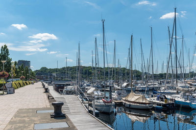 Boats moored at harbor against sky