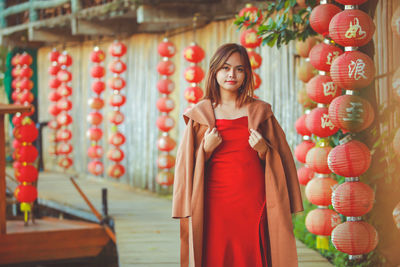 Asian woman wearing cheongsam traditional red dress on chinese new year travel.