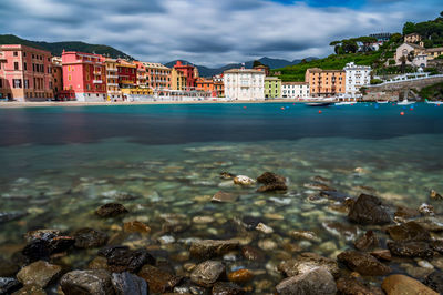 Scenic view of sea by buildings in city