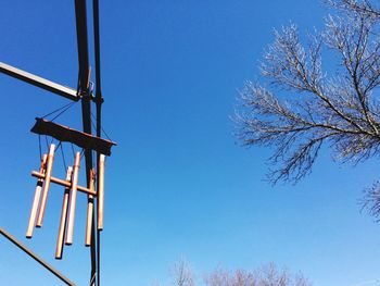 Low angle view of trees against clear blue sky