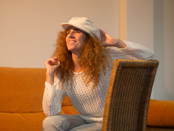 Smiling young woman sitting in hat