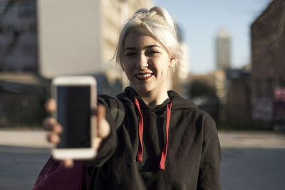 Young woman using mobile phone in city