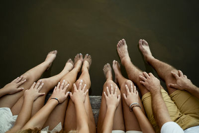 Family dangling legs over lake