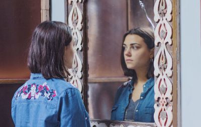 Young woman reflecting on mirror