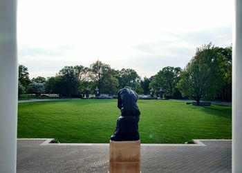 Statue in park against sky in city