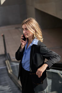 Young woman using mobile phone while standing in gym