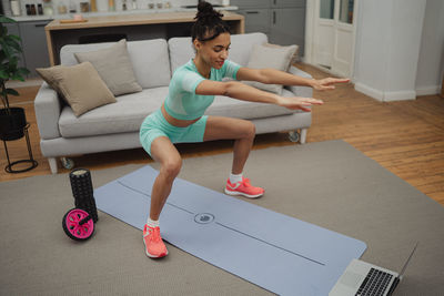 Side view of young woman exercising on table