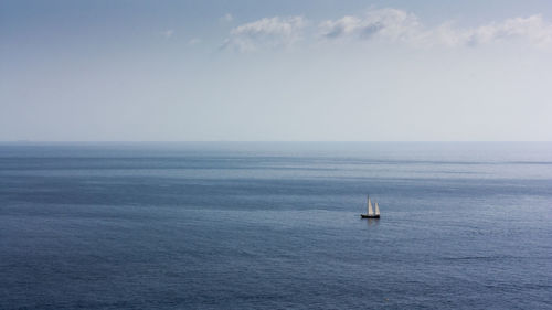 Sailboat sailing on sea against sky