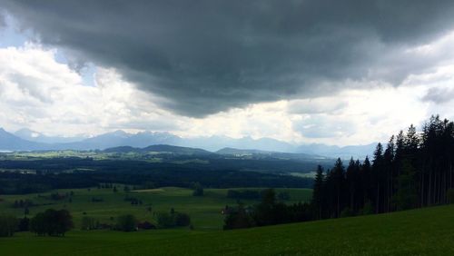 Scenic view of grassy field against cloudy sky