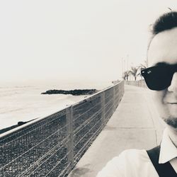 Portrait of man with sunglasses on sea against clear sky