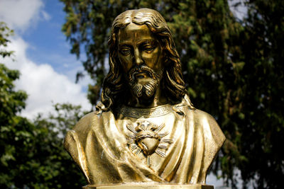 Close-up of jesus christ statue against trees