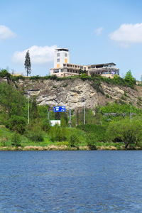 Building by river against sky