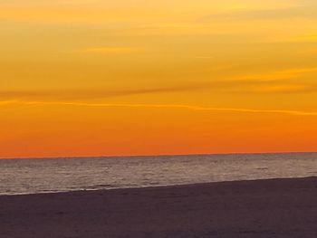 Scenic view of sea against orange sky