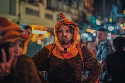Portrait of young people on street in city at night