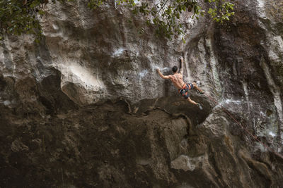 One tattooed man with no shirt rock climbing in mexico