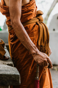 Midsection of monk standing