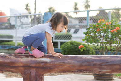 Girl looking away while standing by plants