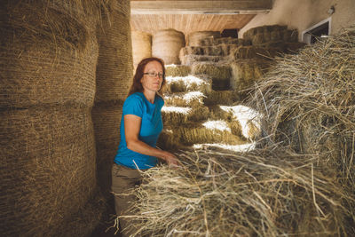 Full length of woman sitting on hay